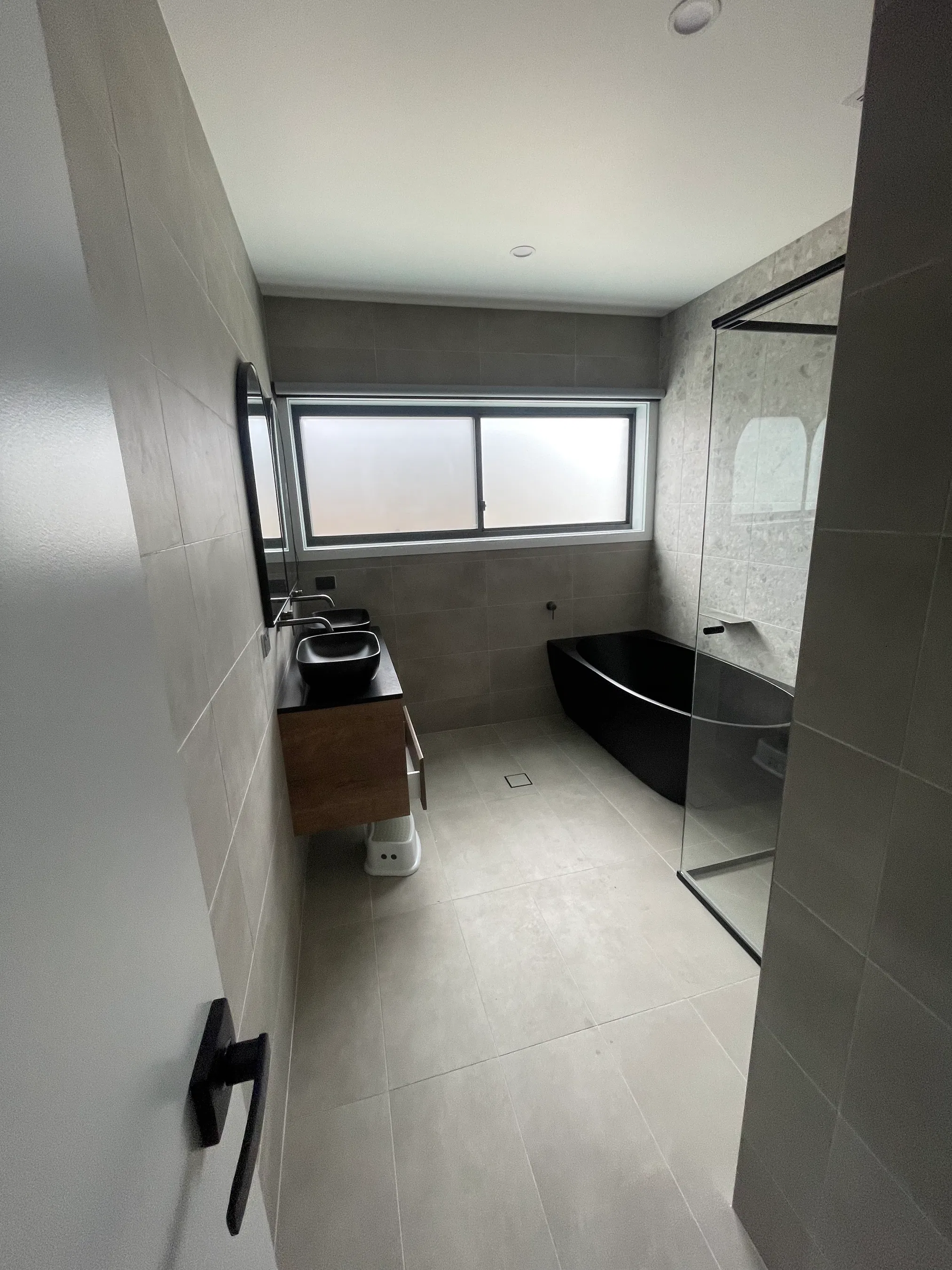 Contemporary bathroom with matte black freestanding tub and timber vanity