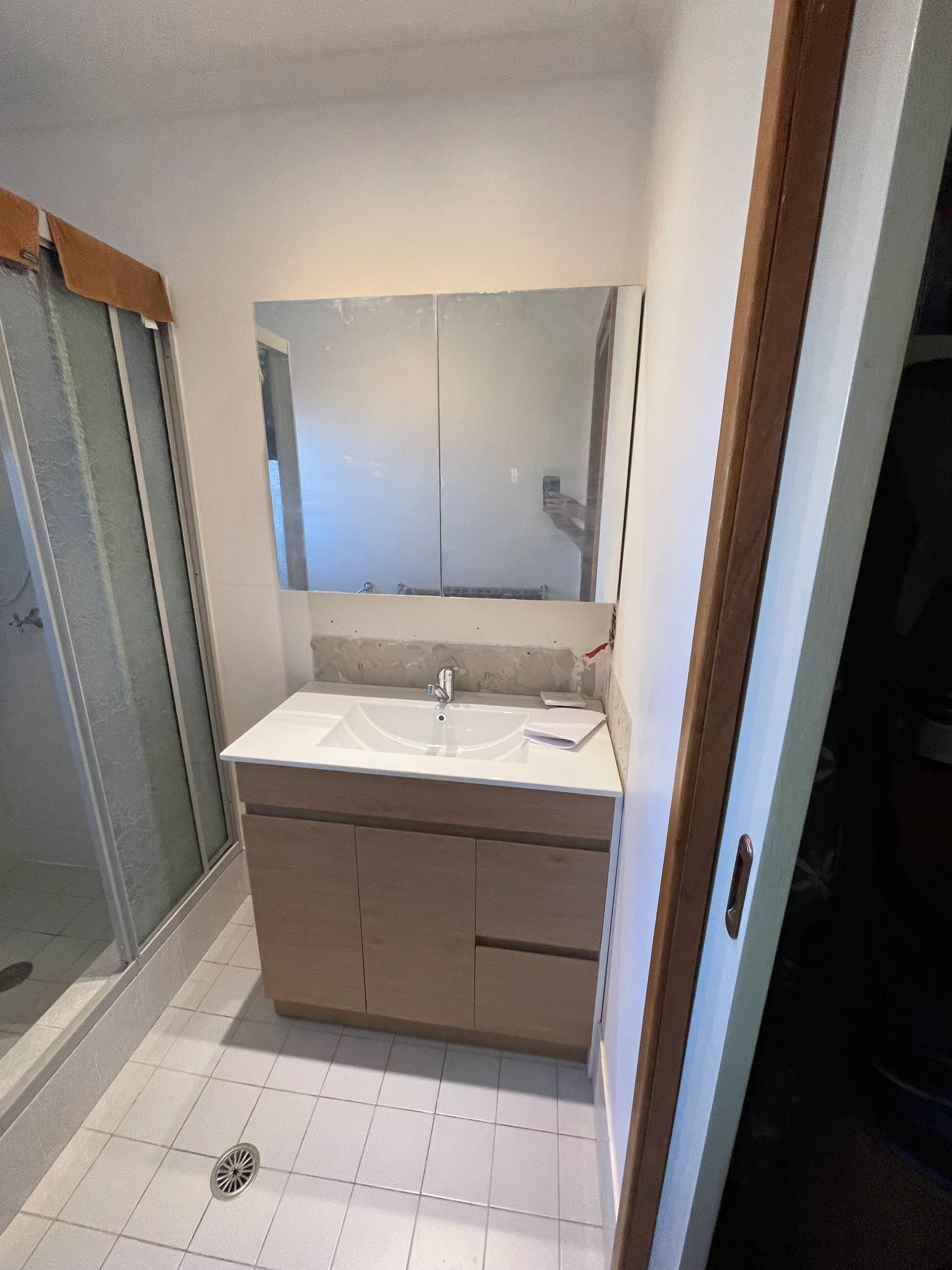 Light oak bathroom vanity with integrated sink and mirrored cabinet