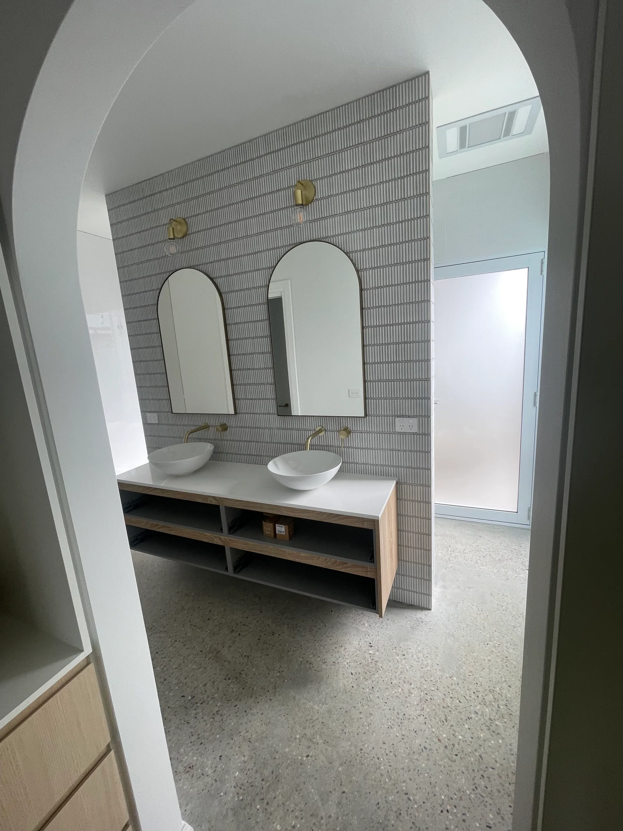 Timber double vanity with arched mirrors and gold tapware