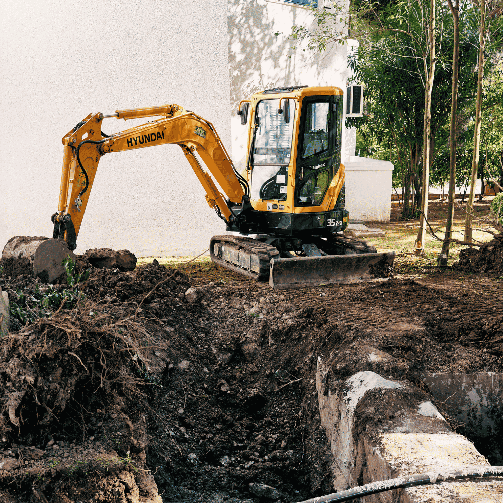 Mini excavator digging trenches for new home plumbing installation