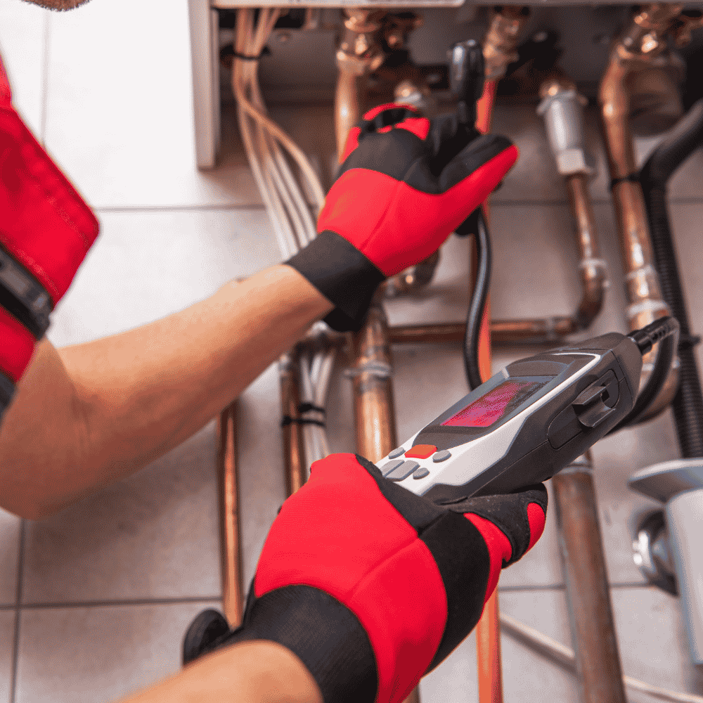 Licensed gas fitter testing copper gas pipework with diagnostic equipment